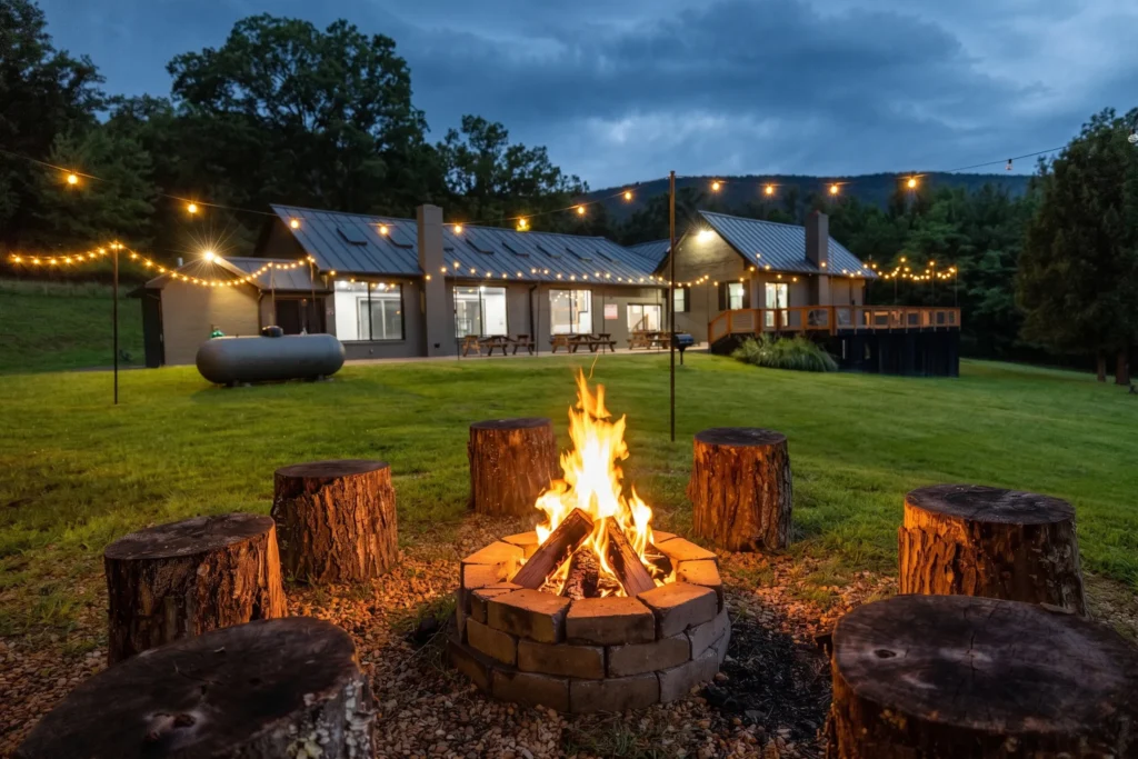 Fire pit under string lights at dusk at The Onyx at Luray