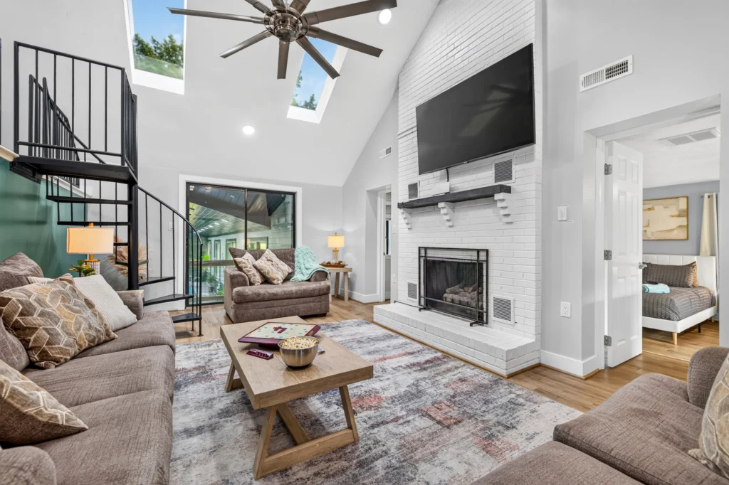 Living room with fireplace and spiral stairs to the loft